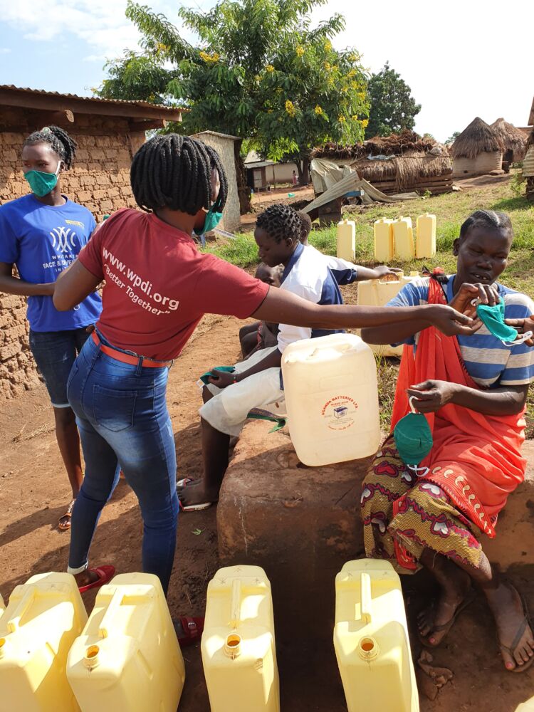 A WPDI Youth in Uganda showing people how to properly wash their hands