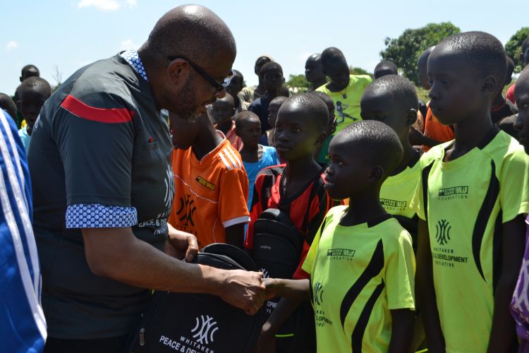 Forest Whitaker shakes hands with youth football player