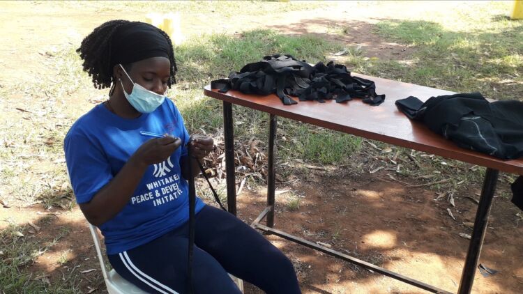 A WPDI youth making masks for the residents in the Kiryandongo Refugee Settlement